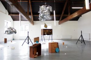 An arrangement of assorted pices of furniture in a gallery space.