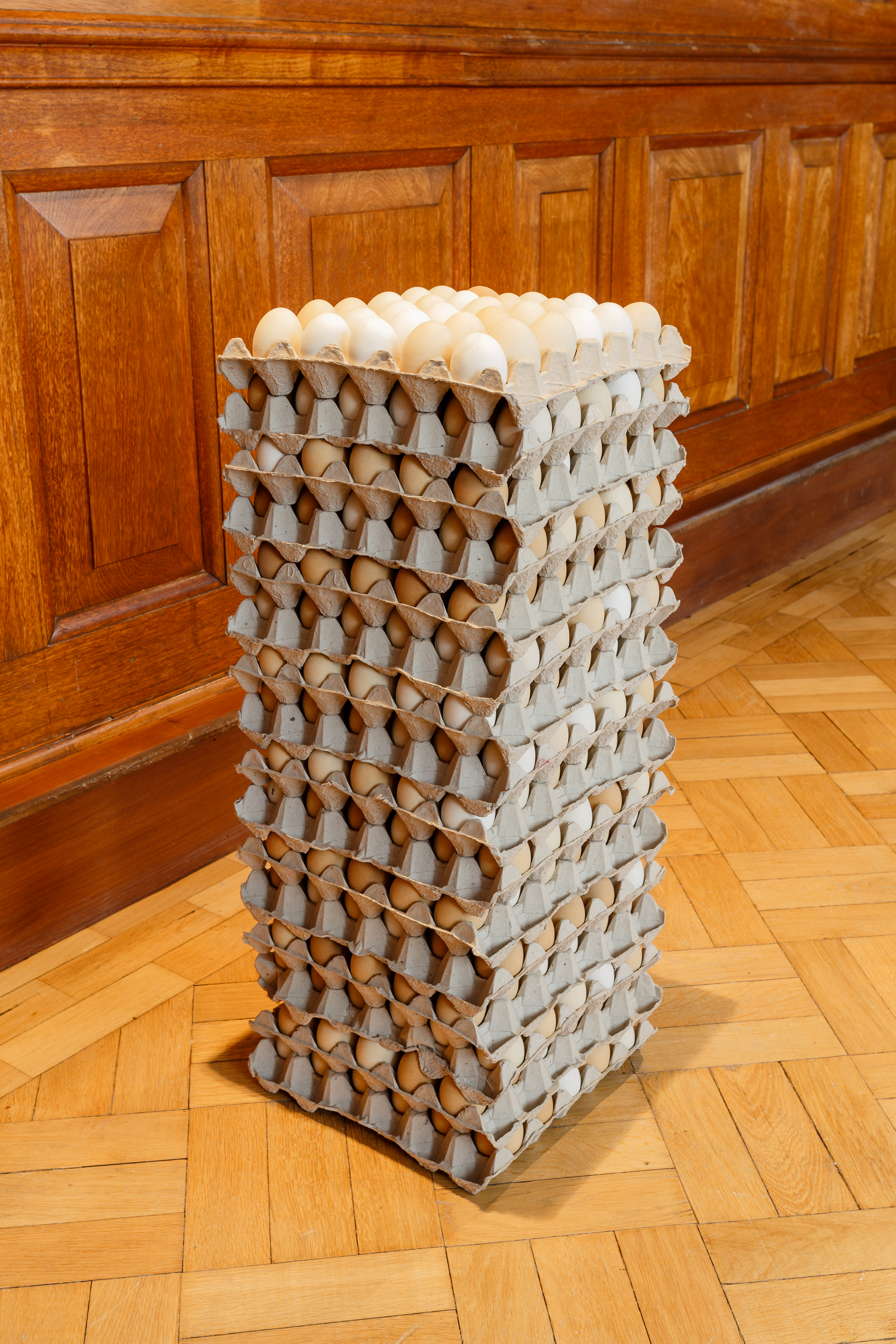 A stack of eggboxes containing eggs. Each box contains around 36 eggs, and there are more than 10 layers to make a tower structure.
