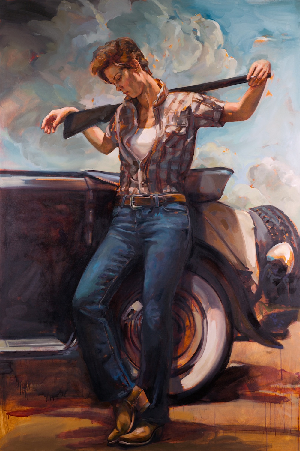 A painting of a white woman who is a cowboy. She holds a rifle across her shoulders and leans on the tyre of a car. She is wearing a checked shirt, open at the chest, blue jeans and brown boots.