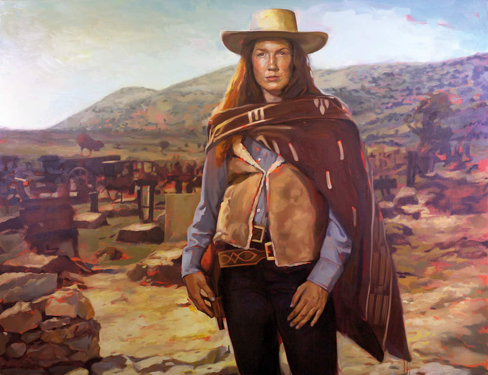 A painting of a white woman who is a cowboy. She wears the traditional hat, a blanket as a shawl and sheepskin waistcoat. She stands in a desert landscape.