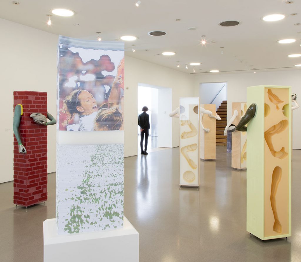 View of a gallery with multiple freestanding sculptures positioned throughout. The works all relate to the body and figure, with many featuring human limbs.