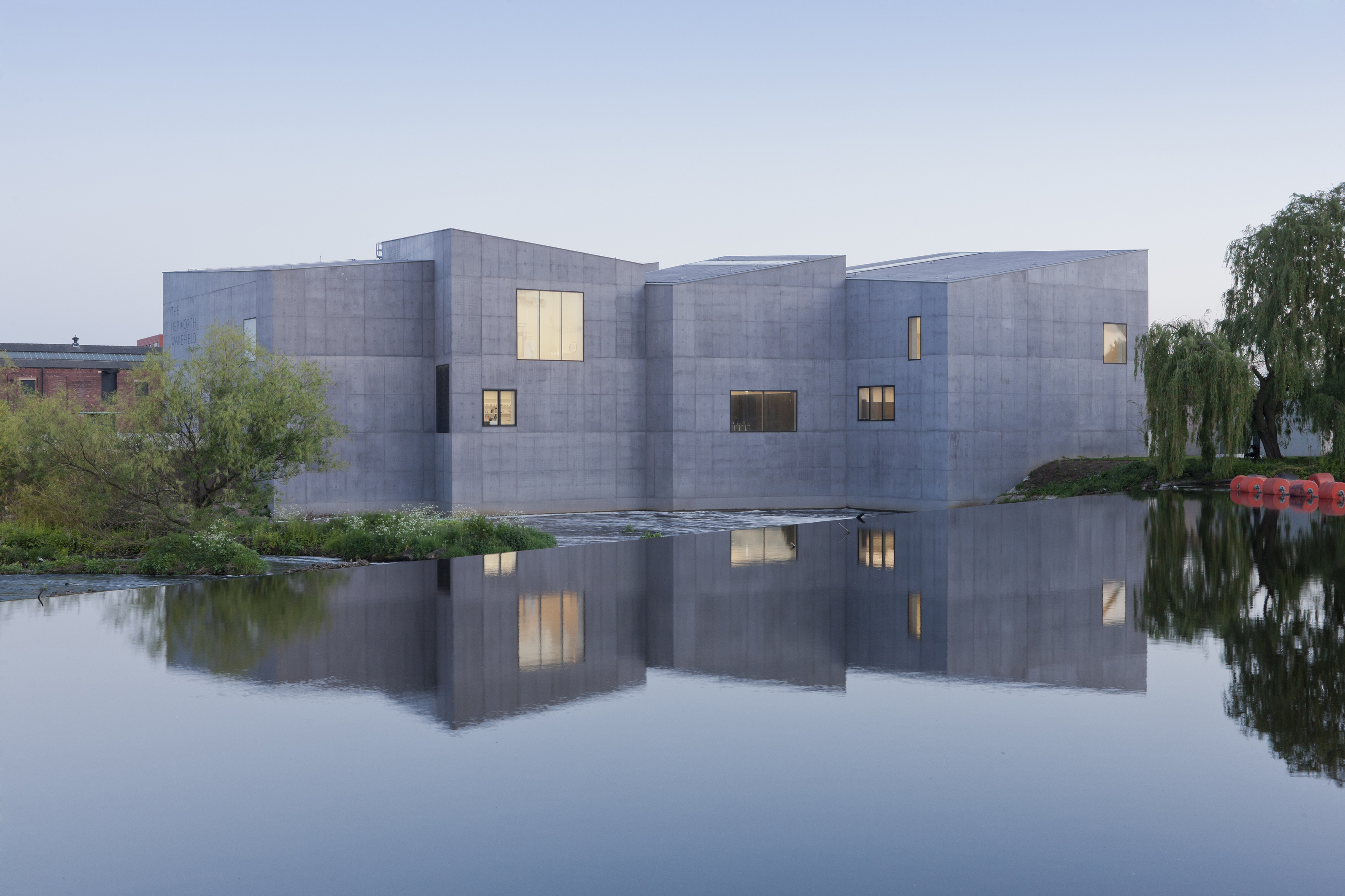 A photograph of the Hepworth Wakefield building, which is made up of low grey blocks in front of the river.