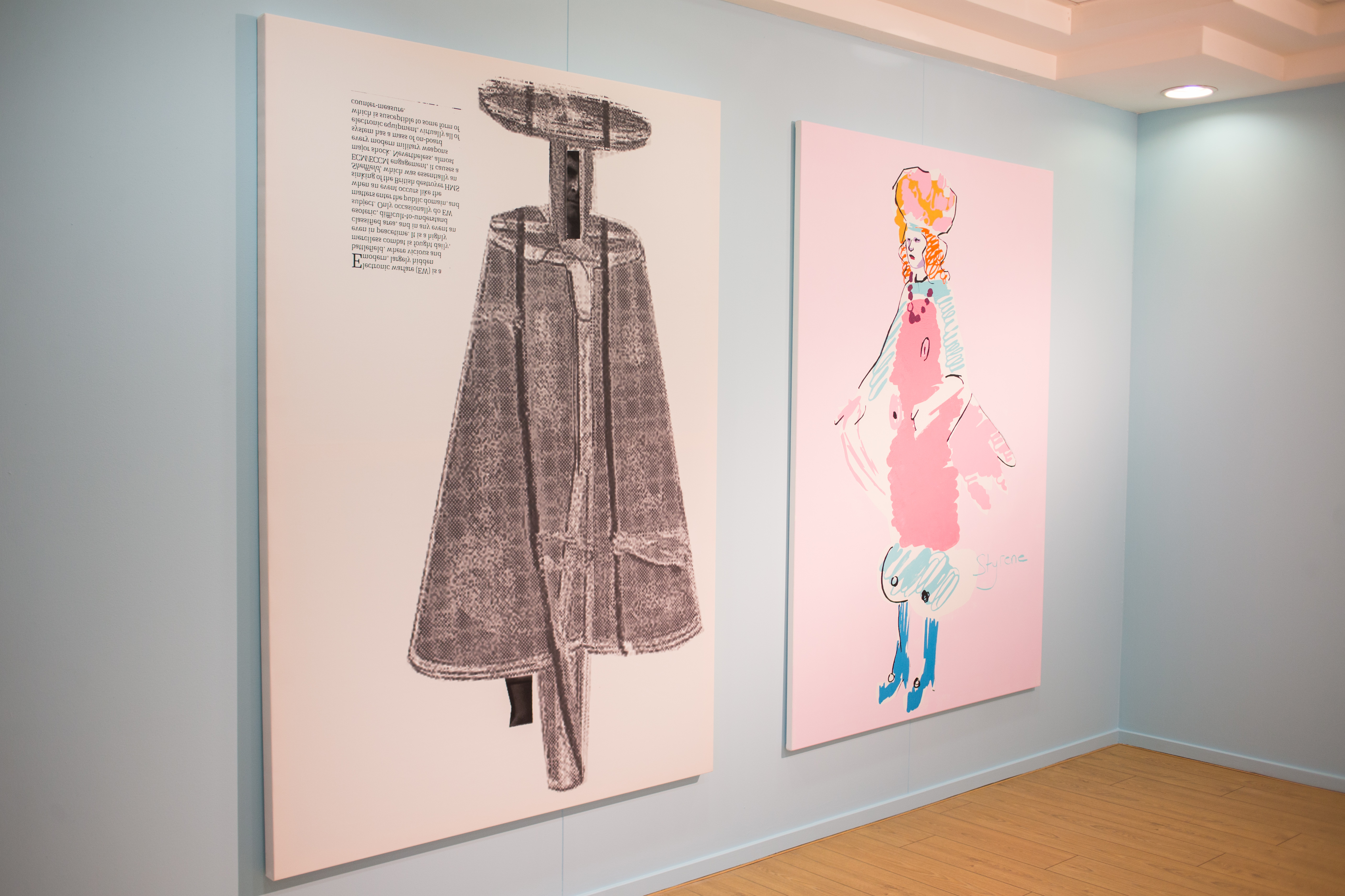 Two works hung in a gallery with pale blue walls and wooden floor. Both artworks depict figures, on the left a figure in grey and on the right a figure in pink and blue costume.