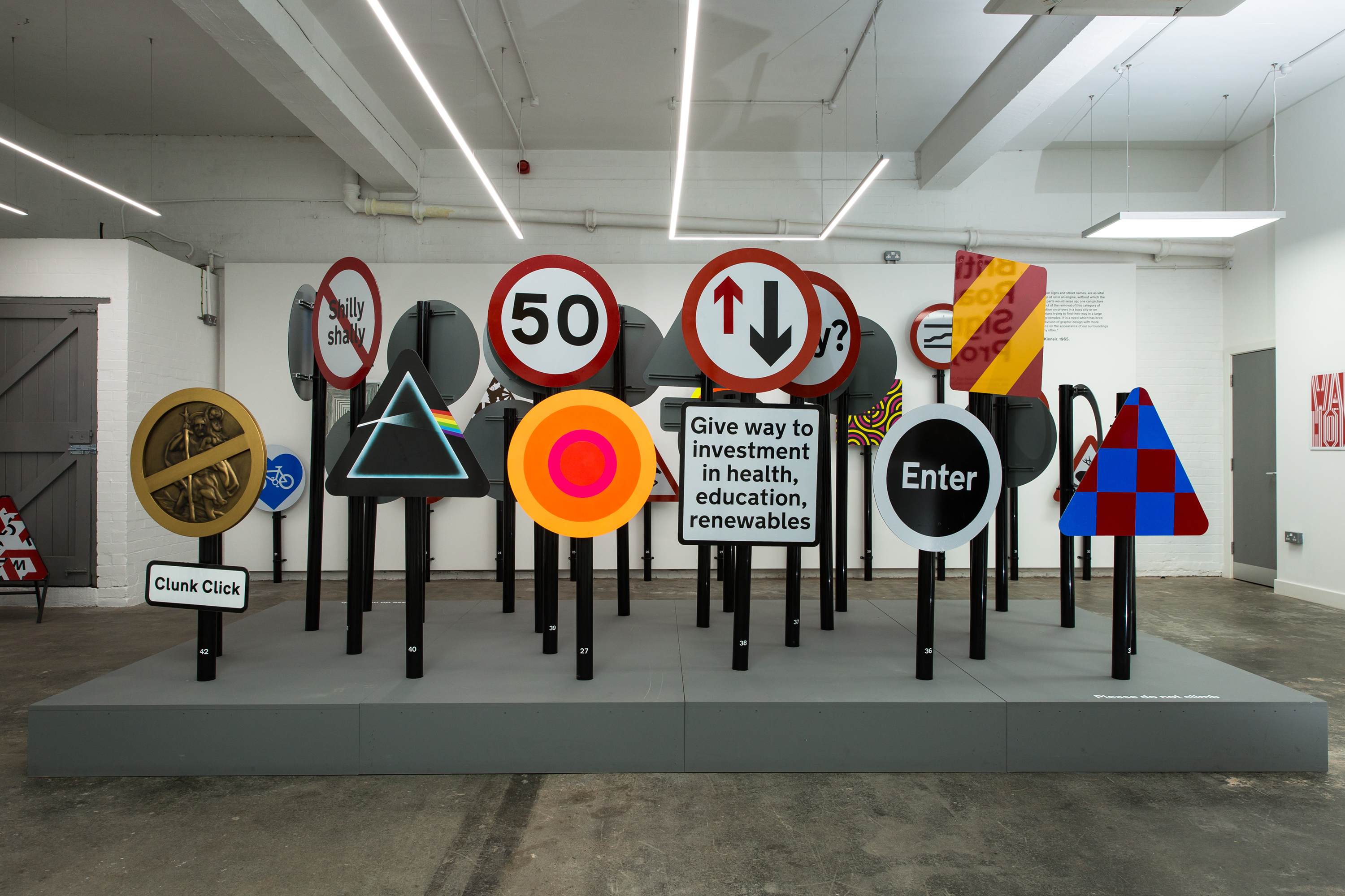 A series of road signs in a gallery space.