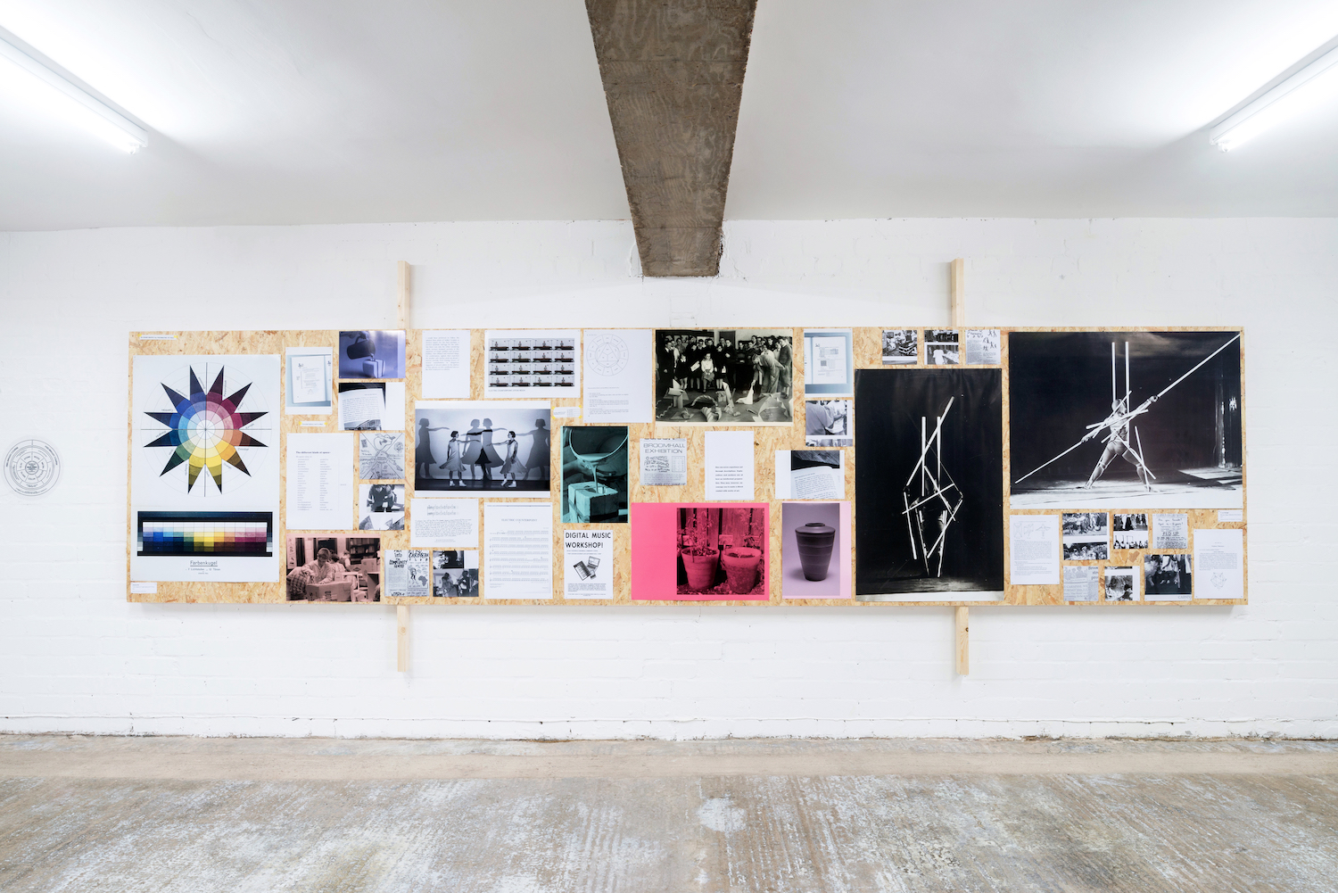 A gallery wall with a selection of posters and images arranged on a chipboard backing.