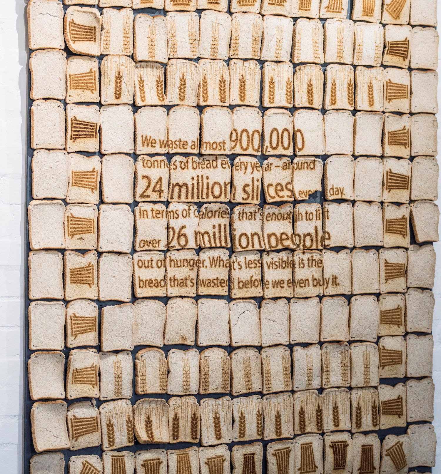 A poster made out of slices of bread. Each slice has part of an image toasted on. Like a mosaic.