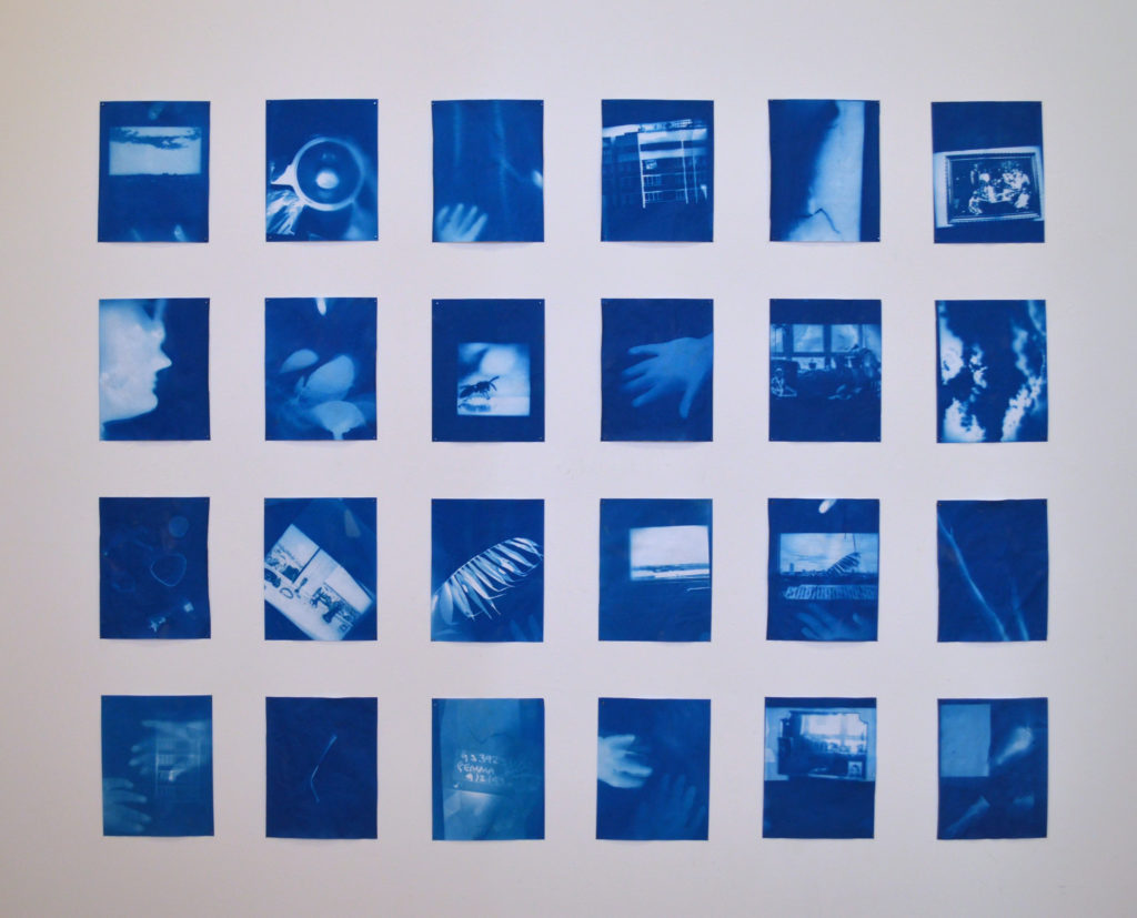 Twenty four cyanotype images displayed in a grid on a white ground. The images are shadows in different degrees of blueness. In one there is a face in profile, in another a hand and in others are views from windows more hands or undistinguishable forms.