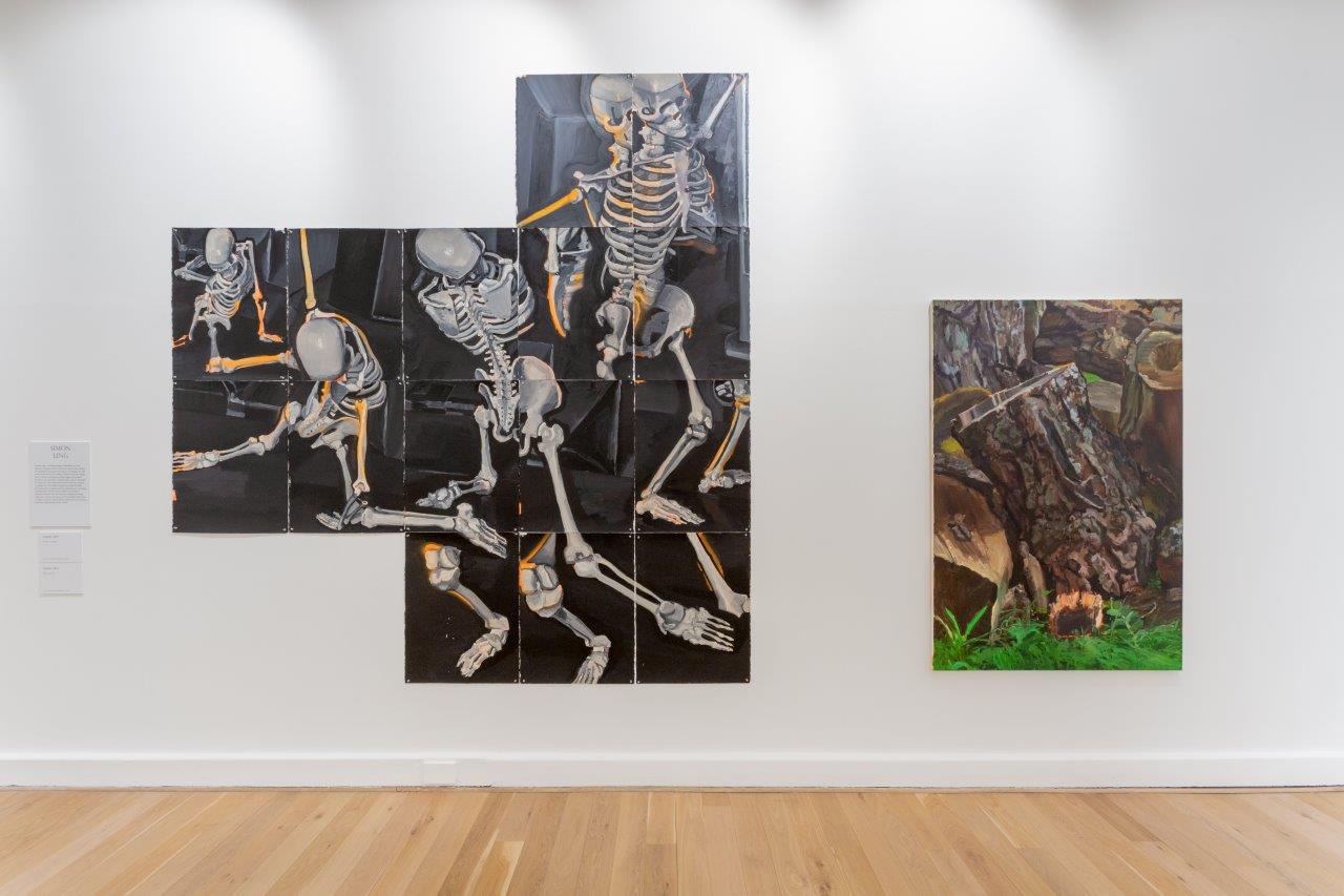 Two paintings in a gallery. On the left a painting of skeletons made up from different panels pieced together. On the right, a painting of tree bark and grass. 
