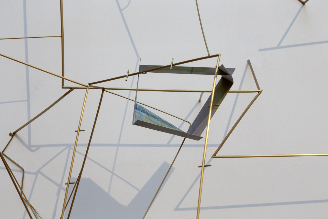 A sculptural work made up of metal rods and painted metal arranged in a geometric pattern.