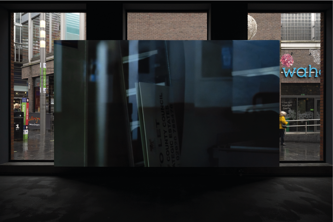 Exhibition image of artist film displayed at Bluecoat, with pedestrians visible through the window in the background