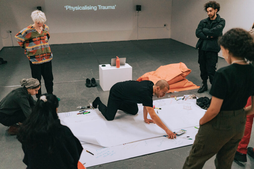 Documentary image showing the artist hosting the workshop being discussed.