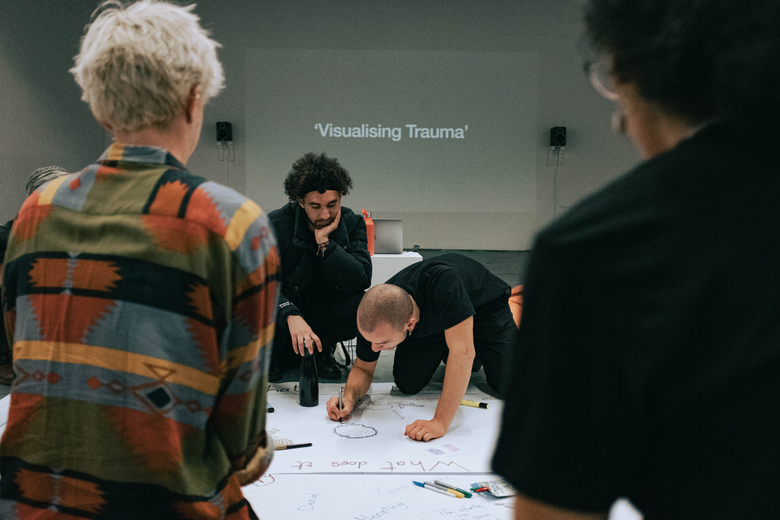 A documentary photograph of the workshop being discussed showing the artist Youcef Hadjazi and workshop participants