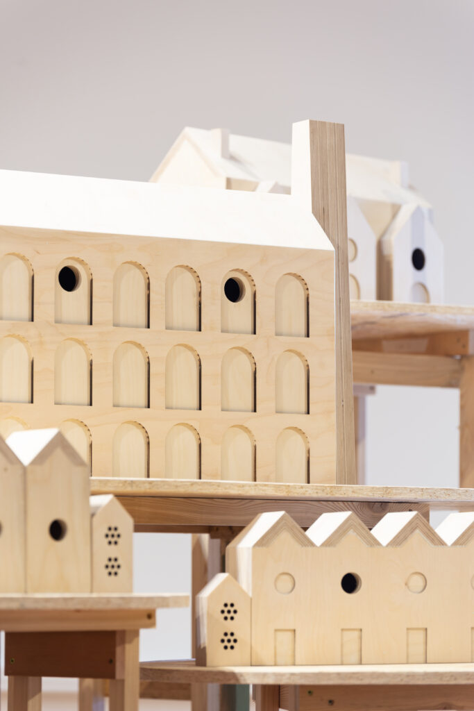 A close up photograph of a number of wooden bird boxes, based on reoccurring architectural forms from Salford.