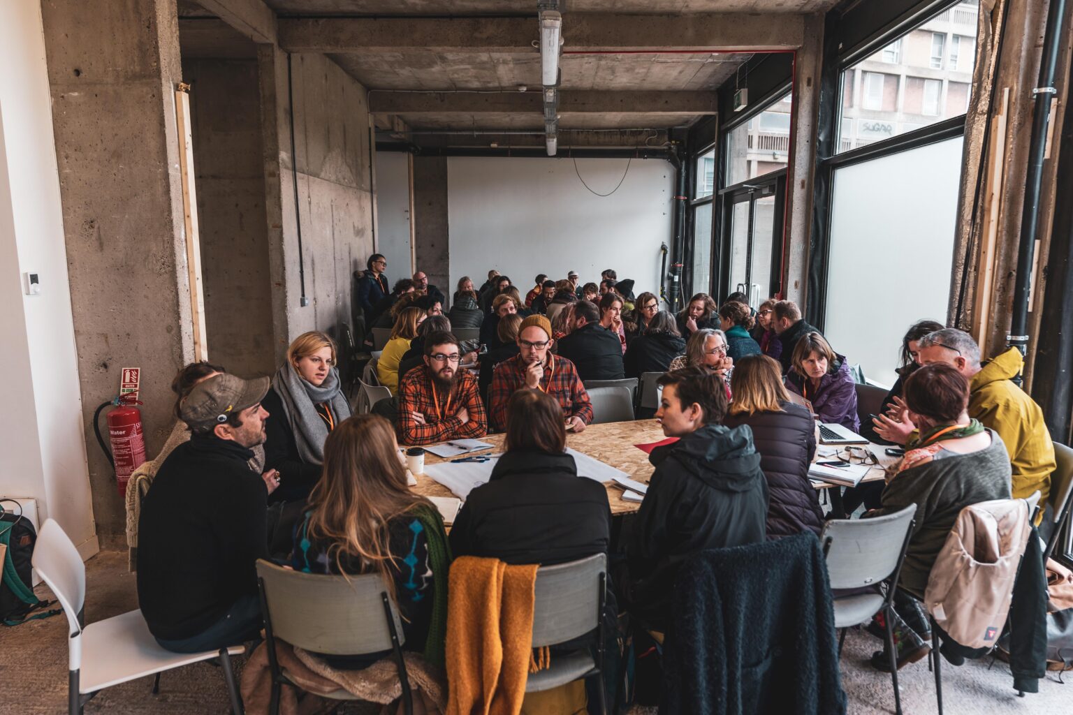 Photo of a group of people in an artspace around a table.