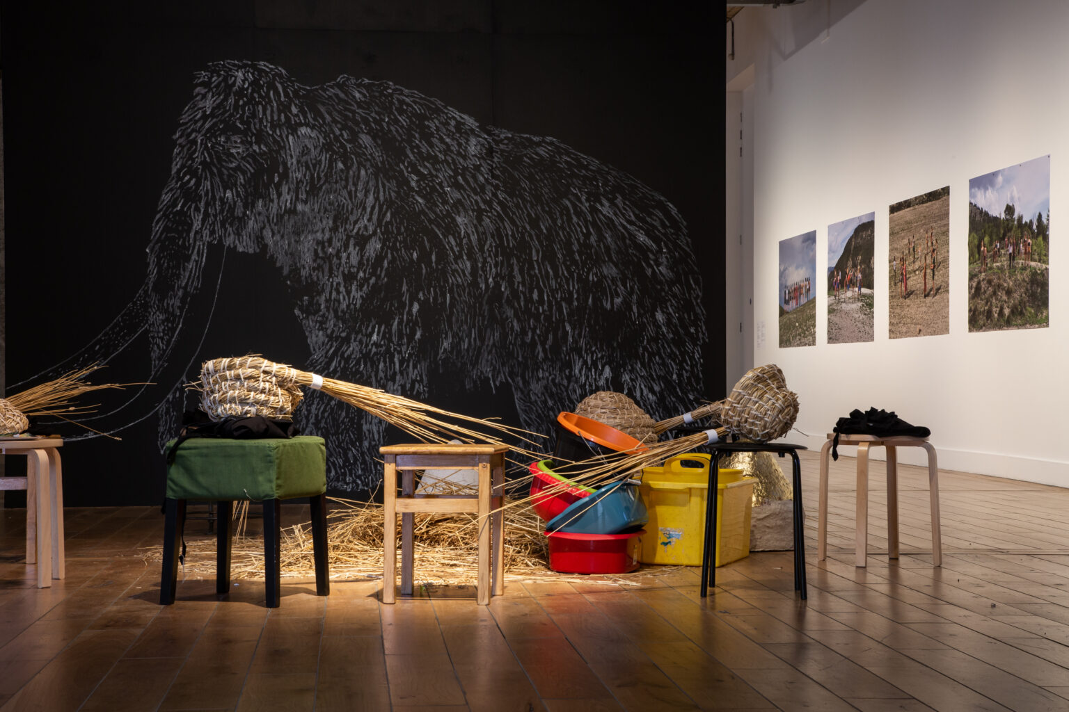 Low stools and plastic buckets in a gallery space