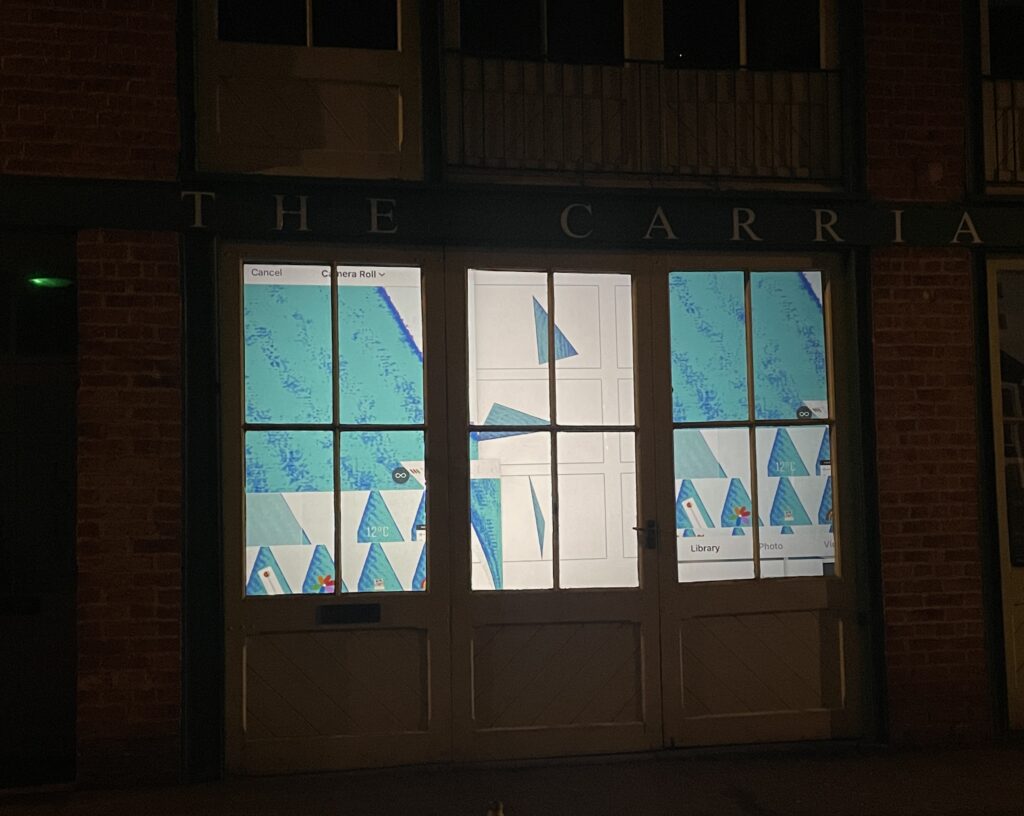 A film, projected onto an interior screen, is viewed externally through a set of window panelled doors.
