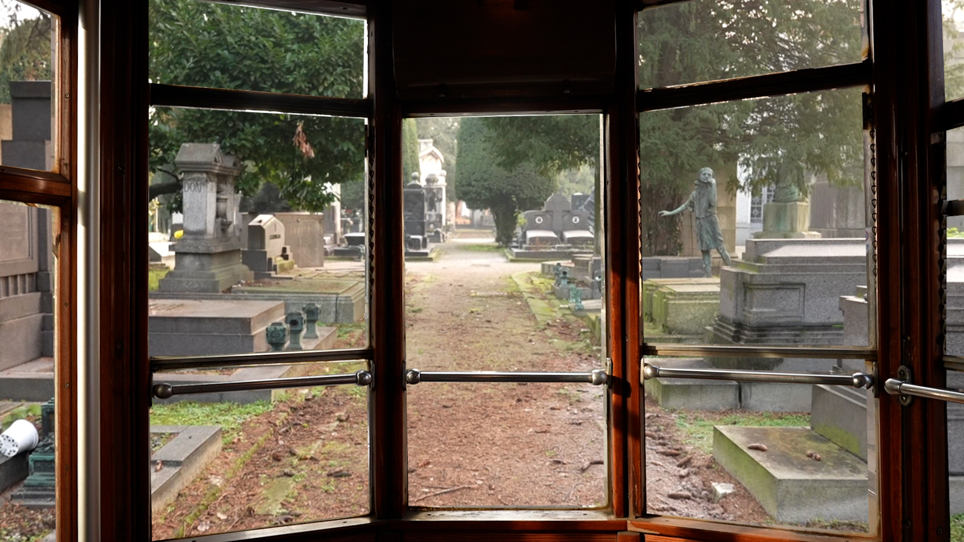 Looking out of the front windows of a trolley-bus, you see a path leading through a mausoleum