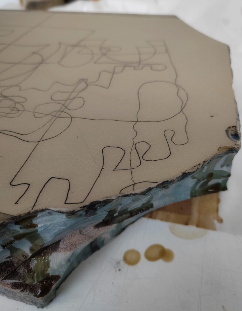 the corner of the litho stone with lines drawn in black on its top surface