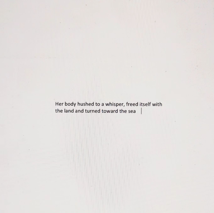 plain black text on a pale background which reads: Her body hushed to a whisper, freed itself with the land and turned towards the sea
