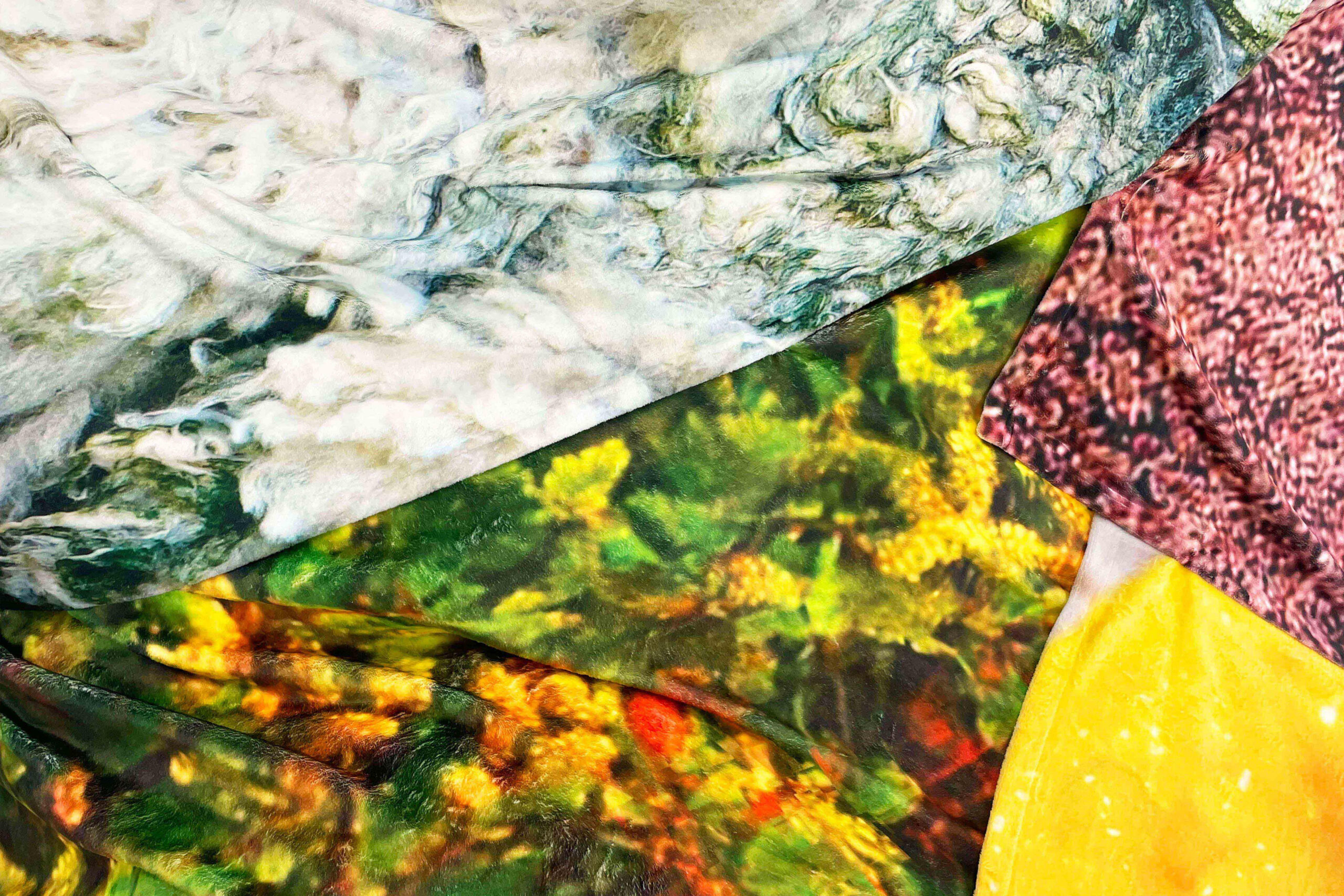 A close up of four swatches of overlaid printed fabric, clockwise from the top: a grey-blue-green swirly cloud like image; a dappled red-black-brown like a close-up on mince meat; bright yellow with flecks of white; deep and lighter green leaves on brown branches with red berries