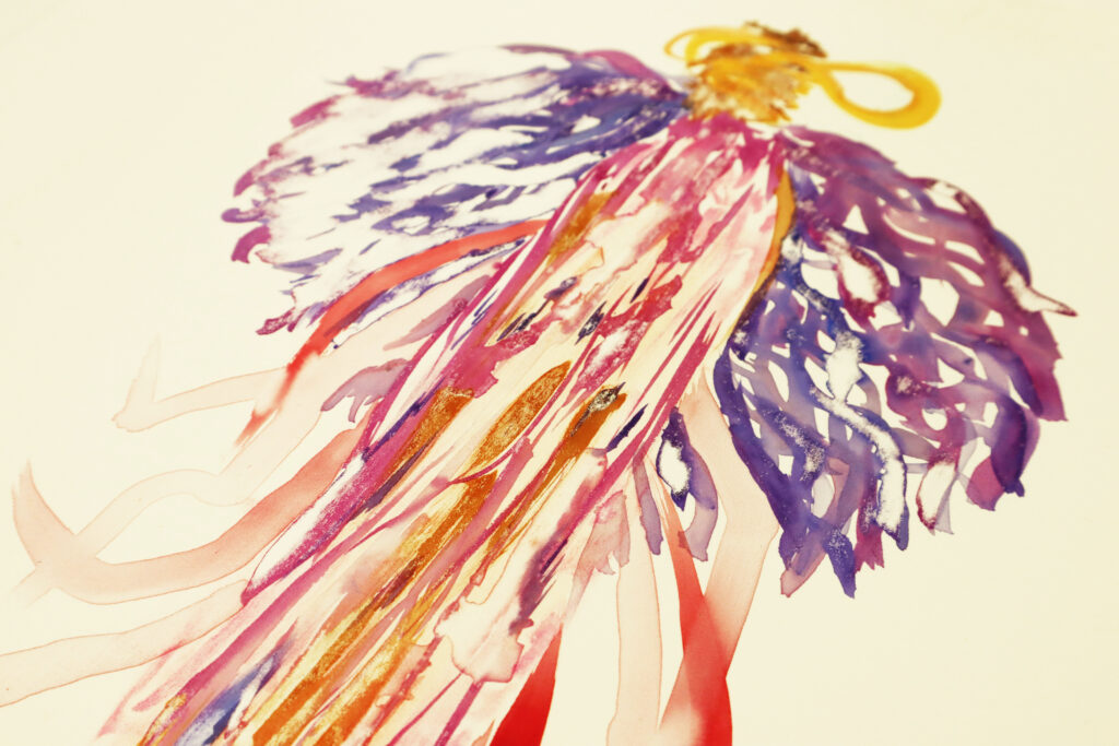 An angled view of a print that is golden, deep mauve, red, pink and violet