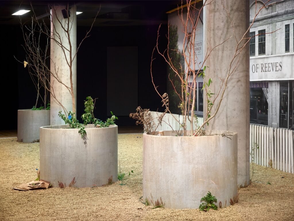 A side view of the front of the stage set where the concrete planters are prominent and the rubbish strewn about can be seen more clearly