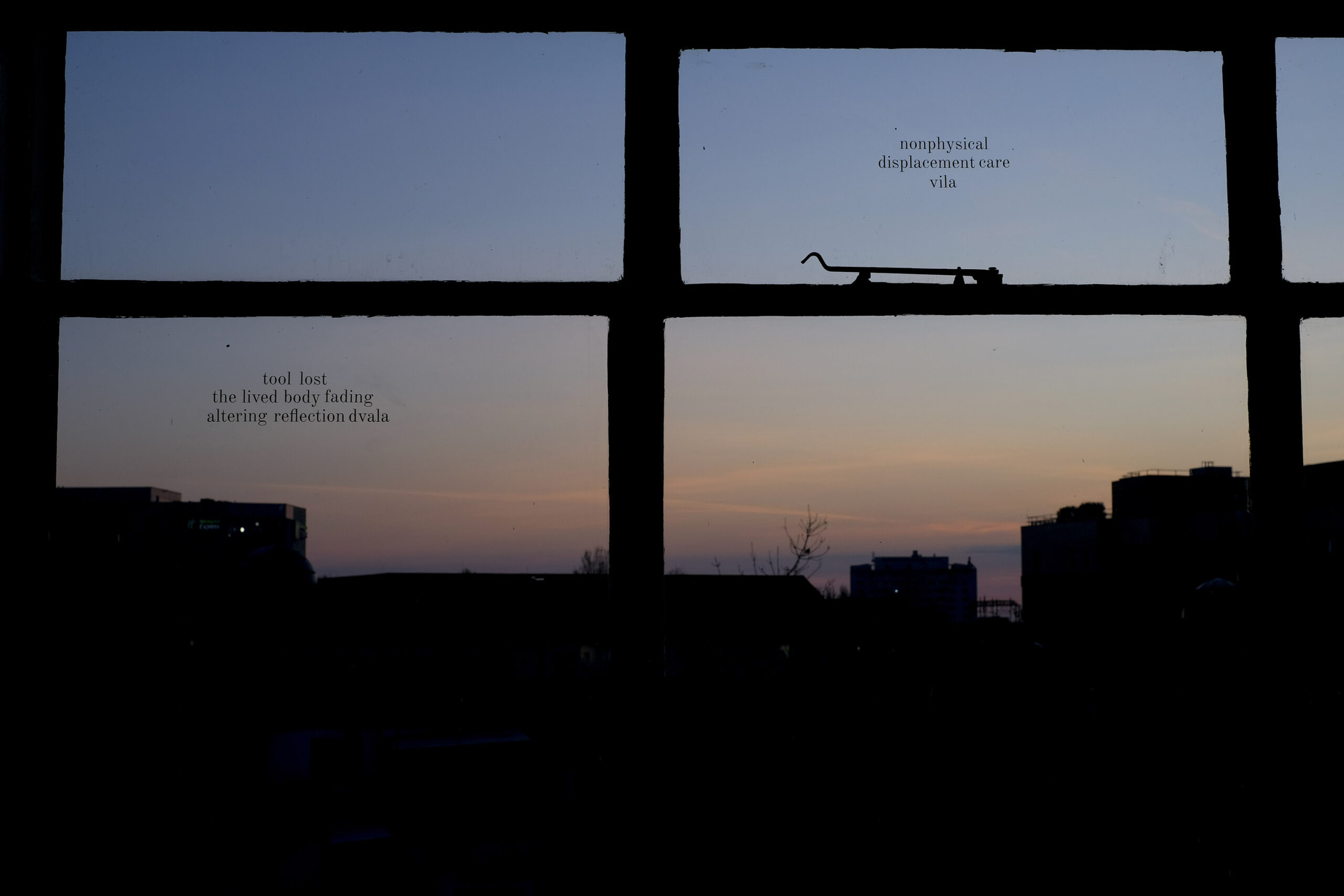 Dusky skies seen through a silhouetted window frame with text on the panes of glass: 'tool lost the lived body fading altering reflection dvala'
