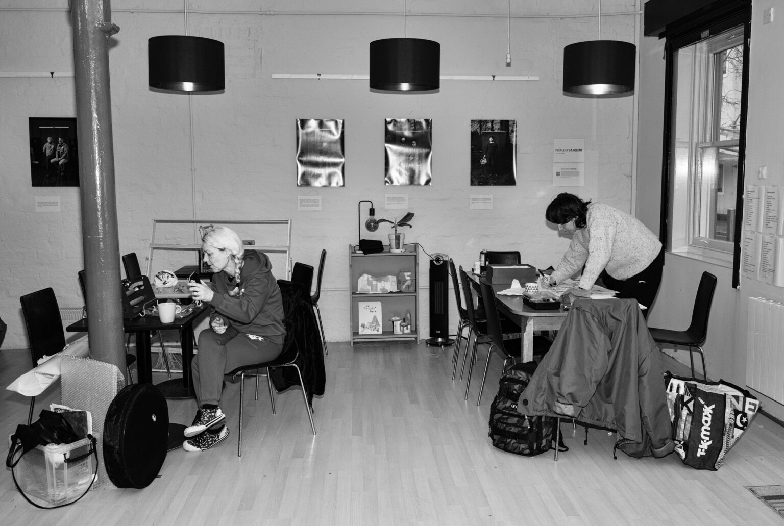 two people are absorbed drawing. They are sat at different tables